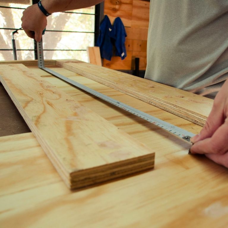 Measuring plywood. Inside the Redditch manufacturing facility for wooden crates